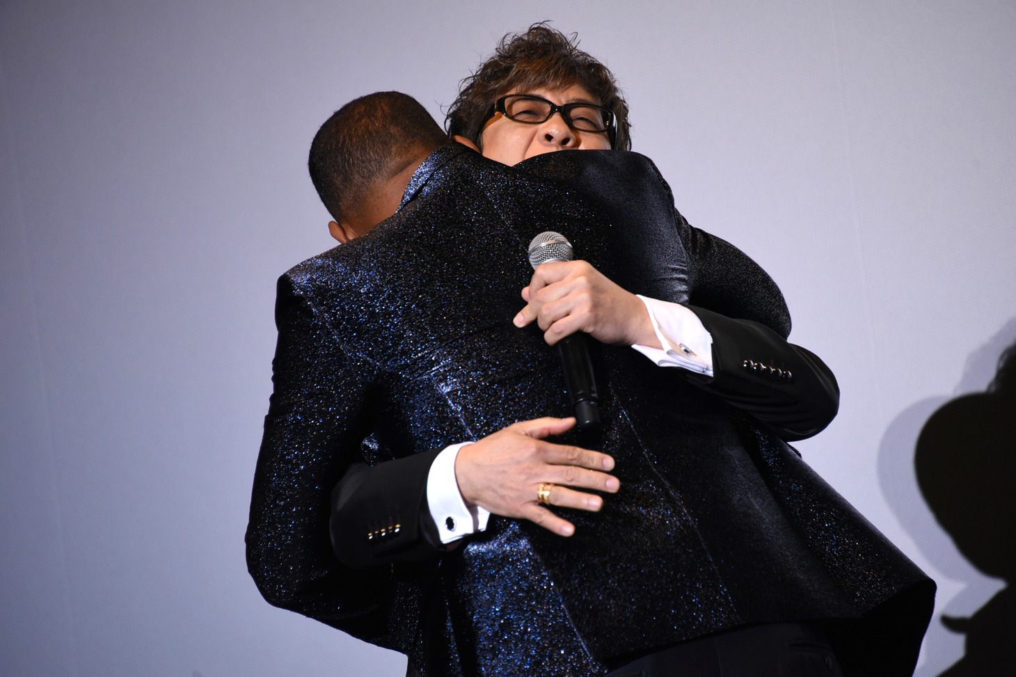 山寺宏一（奥）とハグするウィル・スミス（手前）。