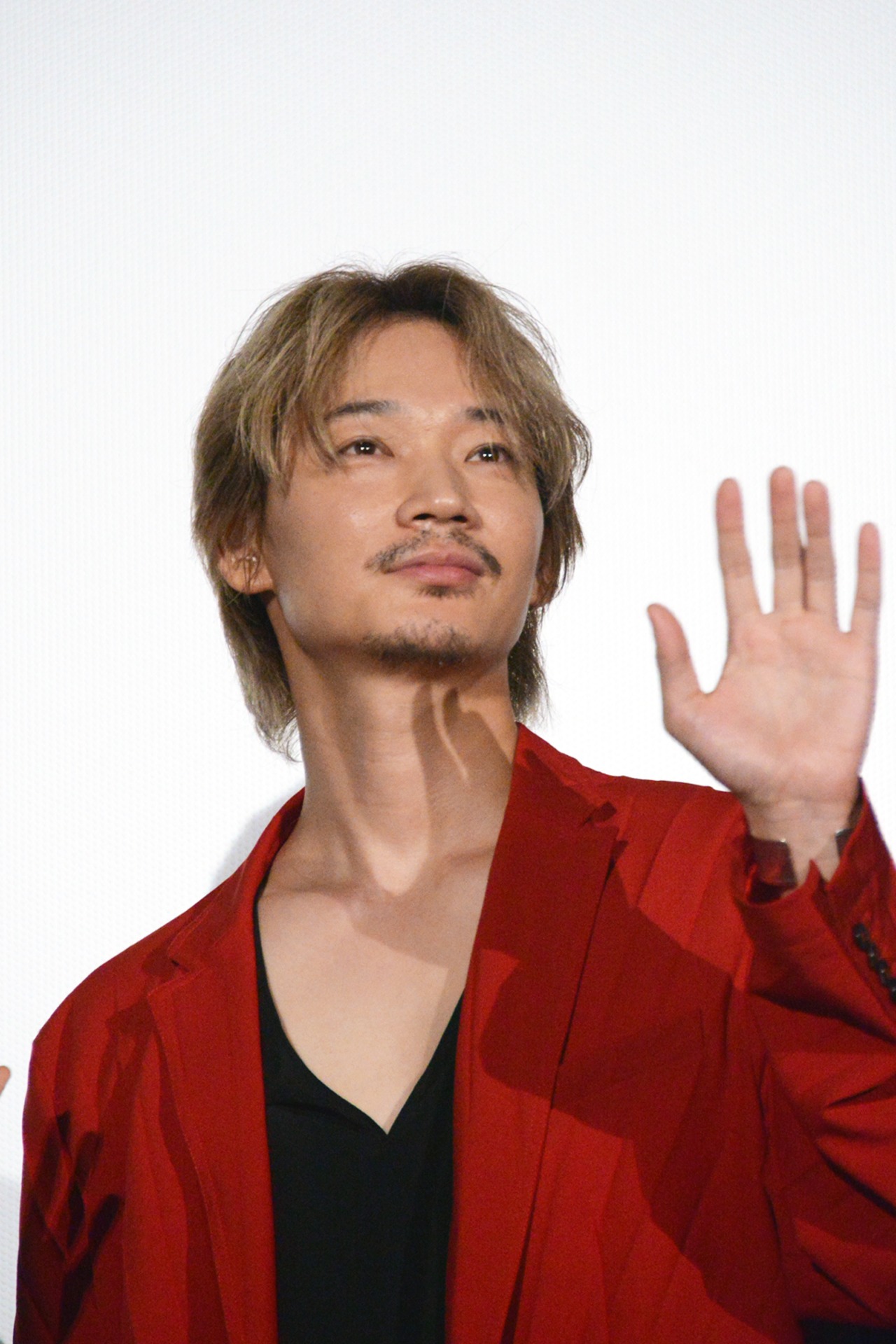 手を振る綾野剛。