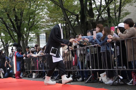 ファンサービスを行う、奇抜な衣装を着た斎藤工。