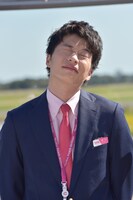 まぶしそうに目をつぶる田中圭。