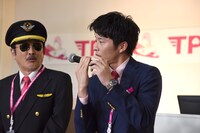 機内アナウンス用マイクの持ち方を再現する田中圭（右）。