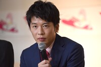 報道陣からの質問を真剣な表情で聞く田中圭。