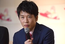 報道陣からの質問を真剣な表情で聞く田中圭。