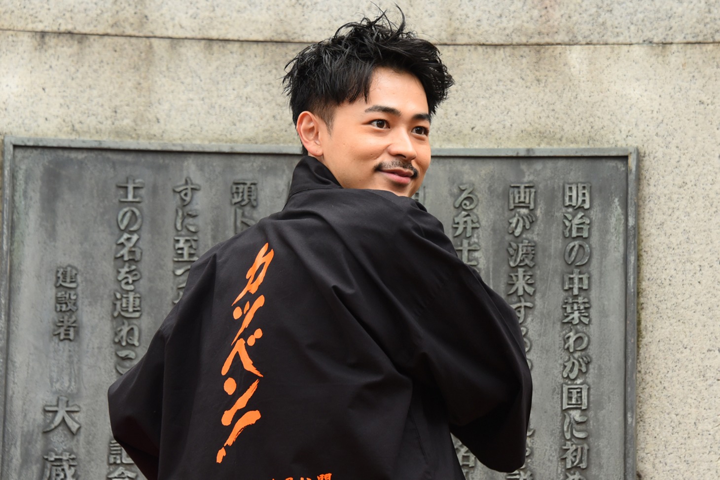 法被を着て背中を見せる成田凌。