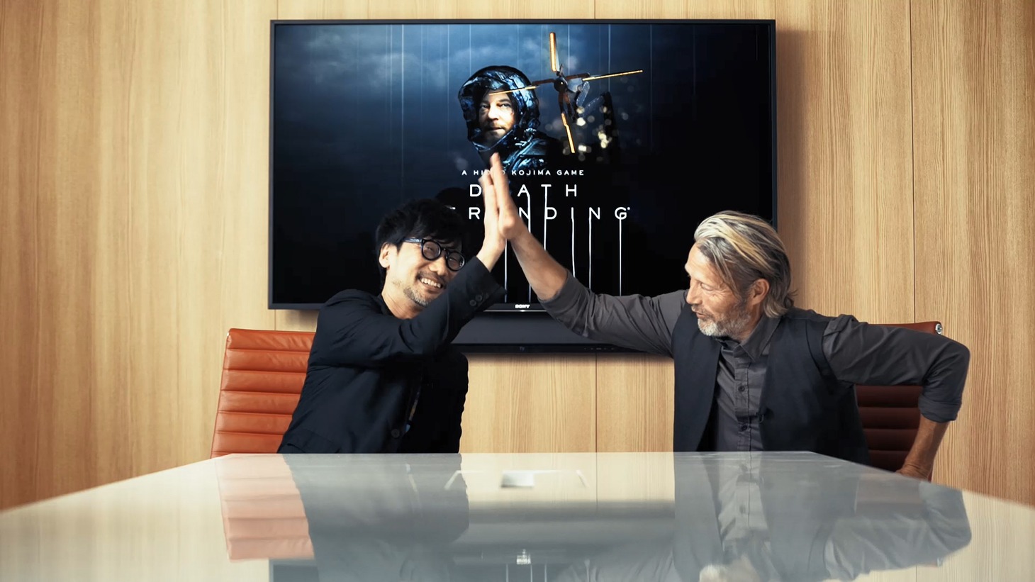 ハイタッチする小島秀夫（左）とマッツ・ミケルセン（右）。