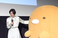 本上まなみ（左）にステージ中央へ誘導されるとんかつ（右）。