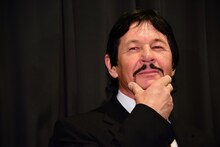 化粧品「マンダム」のCMでチャールズ・ブロンソンが披露したポーズをモノマネするロバート・ブロンジー。