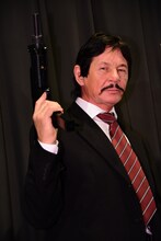 UZIのエアガンを持つロバート・ブロンジー。