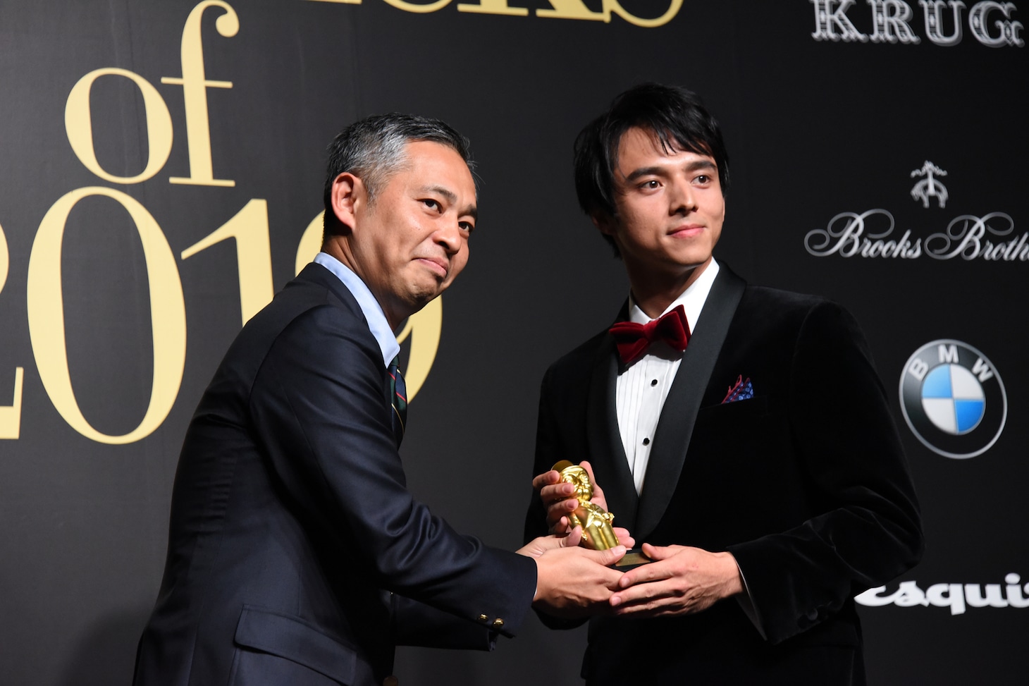 トロフィーを受け取る満島真之介（右）。