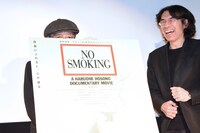 ポスターパネルに隠れようとする細野晴臣。
