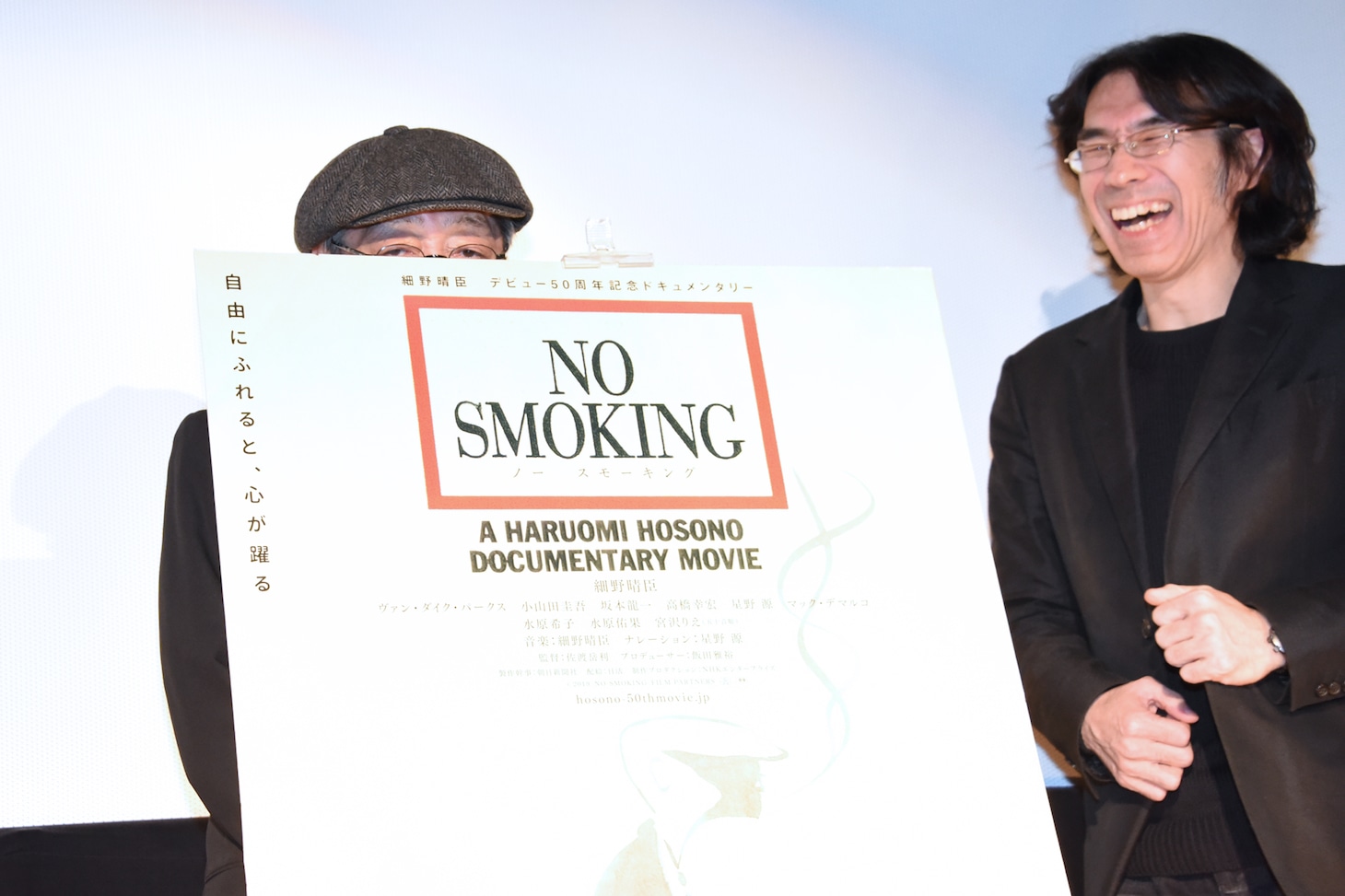 ポスターパネルに隠れようとする細野晴臣。