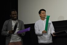 達磨のラップを見守るビーティー（左）と菅原伸太郎（右）。