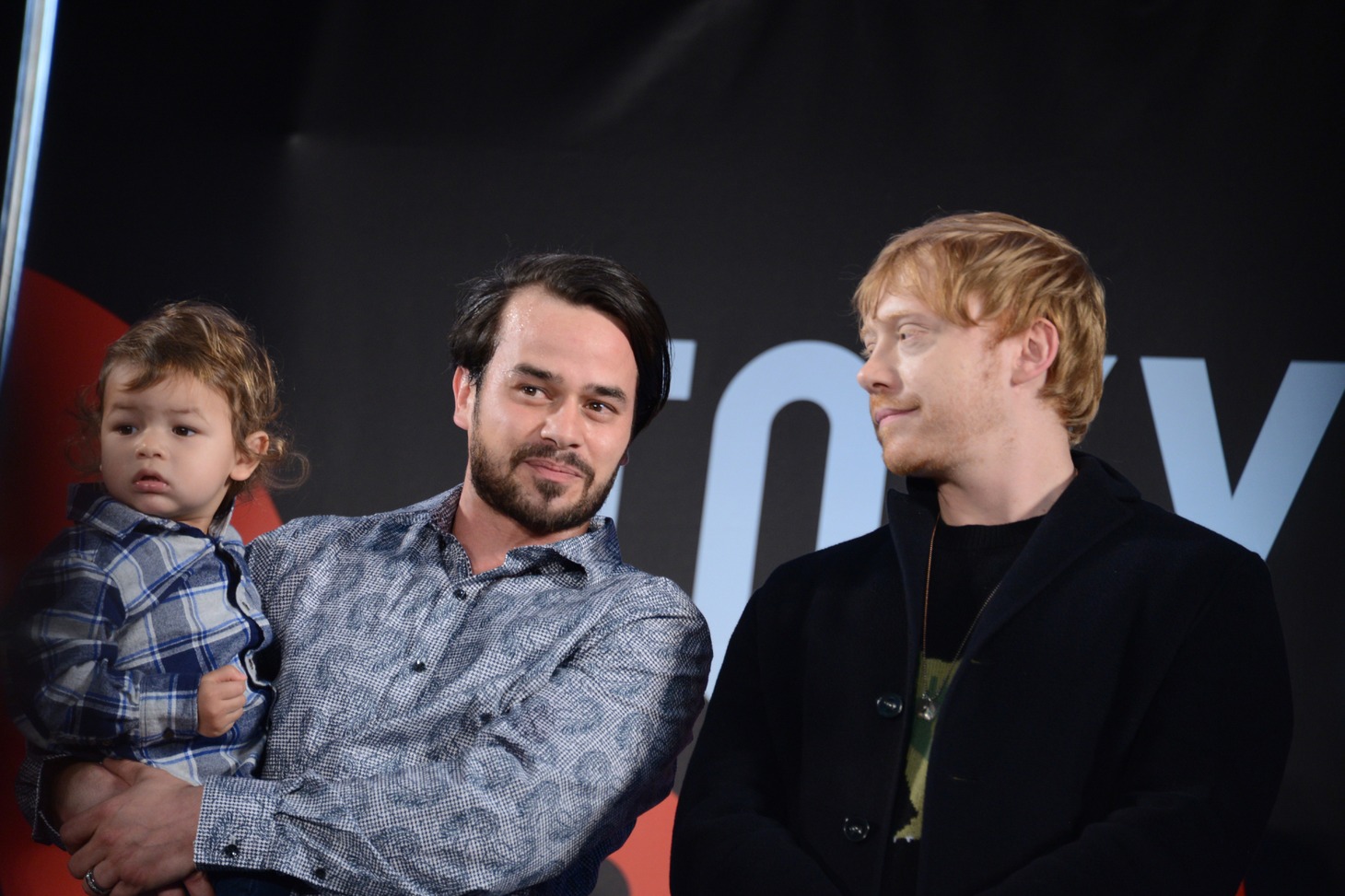 左から、子供と共に登壇したダニエル・ローガン、ルパート・グリント