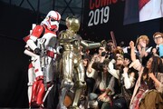 参加者たちに受賞を祝われるC-3POのコスプレイヤー（手前）。