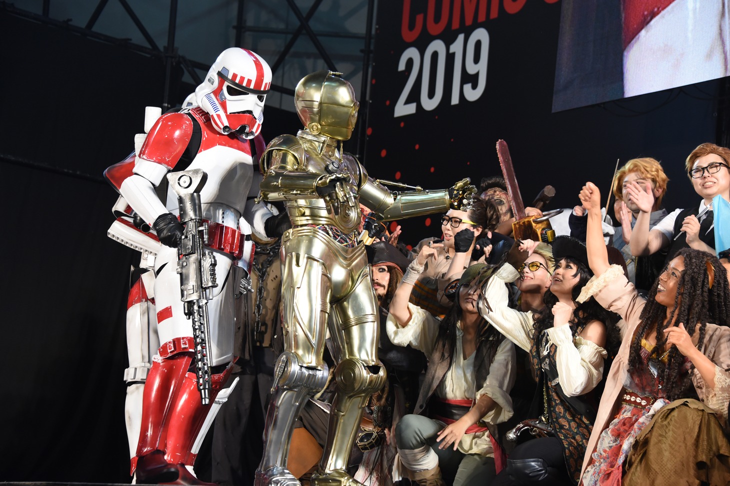 参加者たちに受賞を祝われるC-3POのコスプレイヤー（手前）。