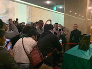 賞状とトロフィーを撮影しようと集まったファン。