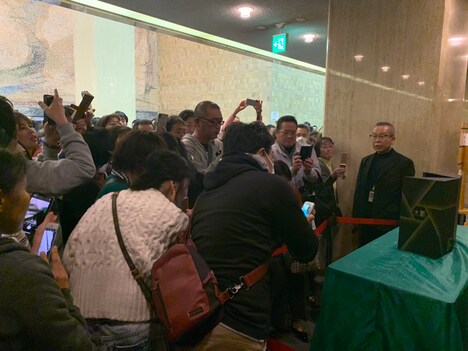 賞状とトロフィーを撮影しようと集まったファン。