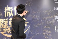 サインをする竹内涼真。