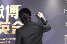 サインをするディーン・フジオカ。