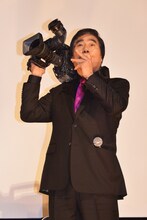 ホラ貝の笛を吹く村西とおる。