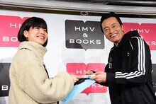 ファンミーティングに臨む遠藤憲一（右）が、しっかりカメラ目線を送る様子。