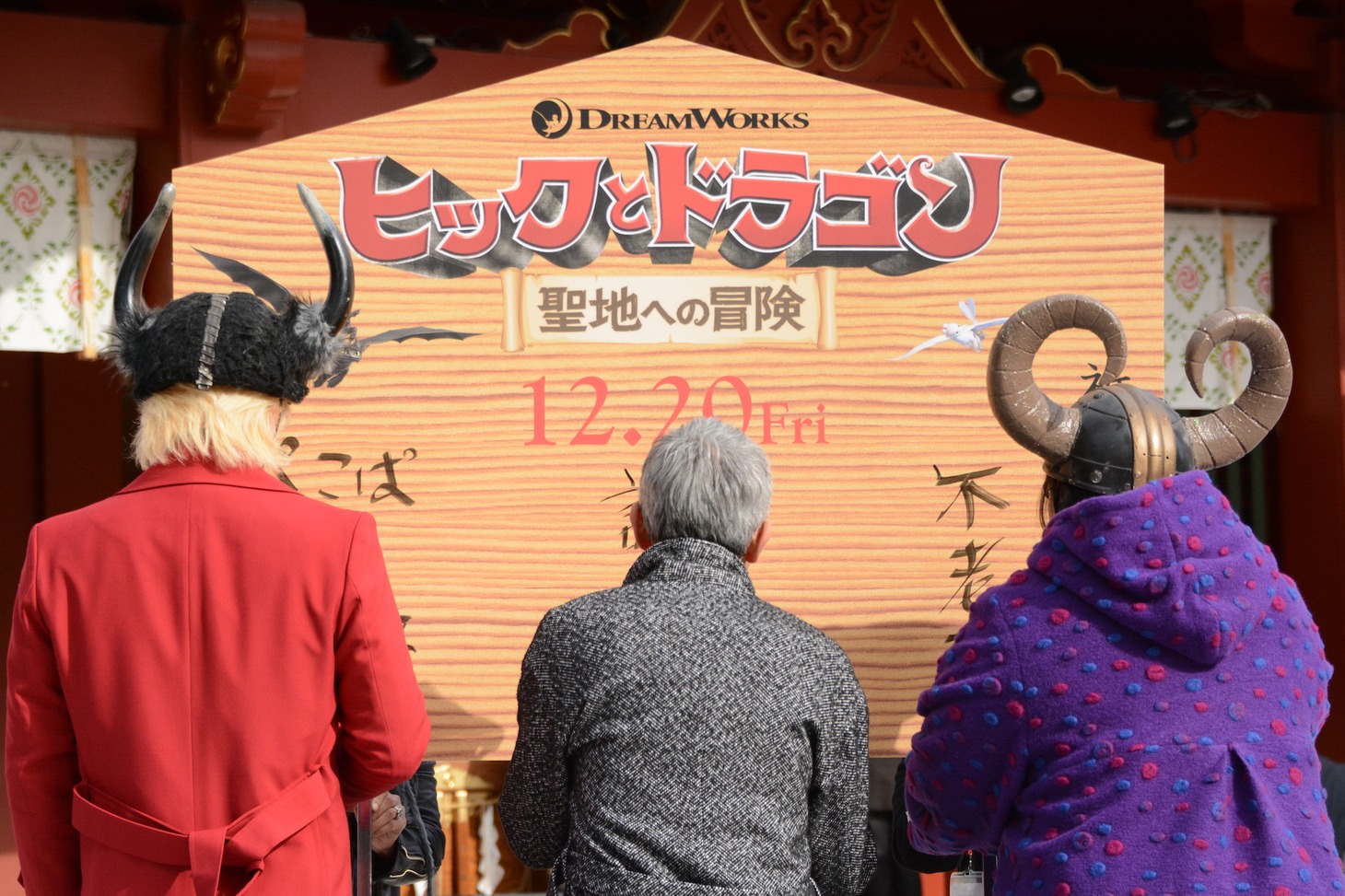 巨大絵馬に願いを書くカズレーザー（左）、松重豊（中央）、安藤なつ（右）。