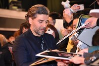 サインをするオスカー・アイザック。