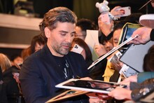 サインをするオスカー・アイザック。