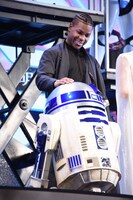 R2-D2に手を添えるジョン・ボイエガ。
