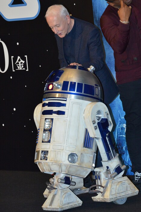 R2-D2をなでるアンソニー・ダニエルズ。