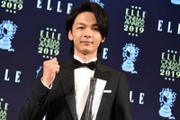トロフィーを受け取りガッツポーズを見せる中村倫也。