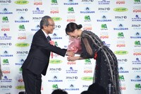 小日向文世（左）から花束を受け取る長澤まさみ（右）。