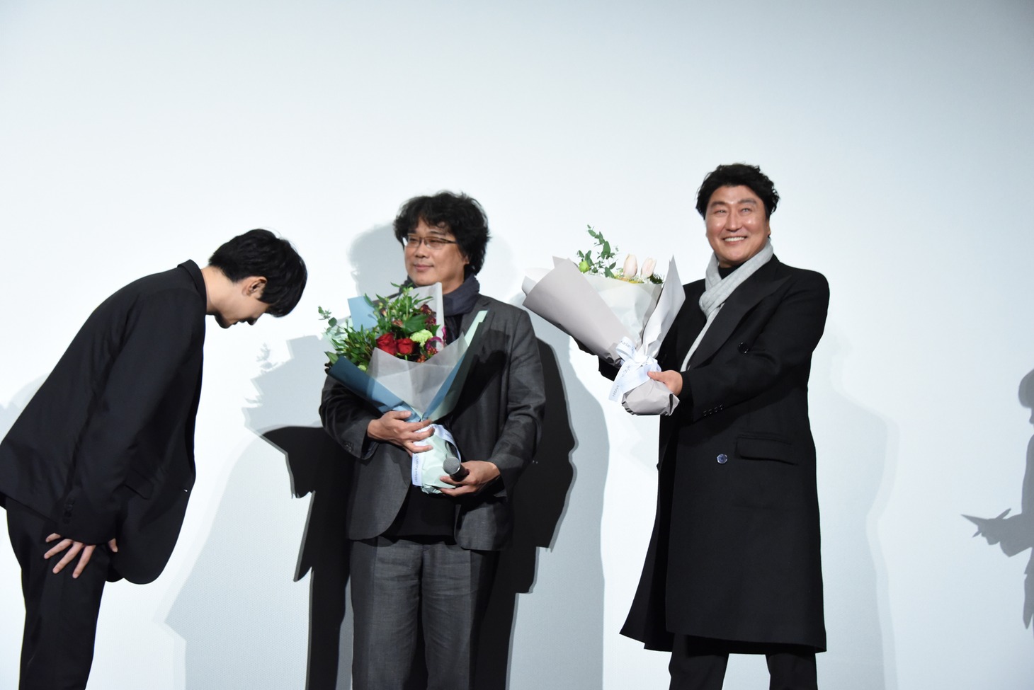 ポン・ジュノ（中央）とソン・ガンホ（右）に花束を渡した吉沢亮（左）。
