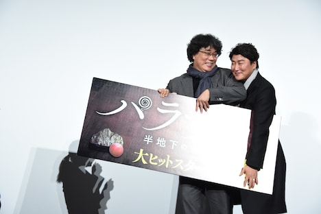 パネルを片付けながら退場するポン・ジュノ(左)とソン・ガンホ(右)。