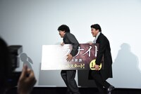 パネルを片付けながら退場するポン・ジュノ（左）とソン・ガンホ（右）。