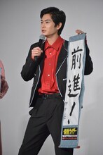 「前進！」としたためた書き初めを披露する押田岳。