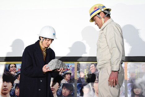 貫通石の重さを体感する高杉真宙（左）。