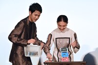 テープを積む久保田紗友（右）に声援を送る葉山奨之（左）。