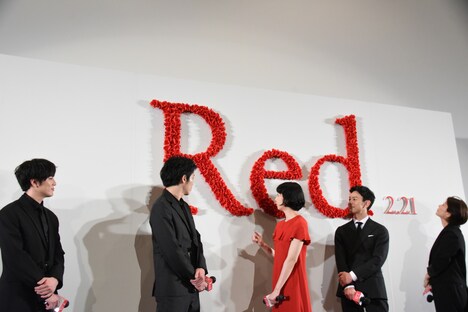 バラで作られたロゴを眺める登壇者たち。