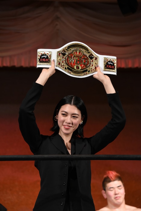 「WORLD HORROR QUEEN」のチャンピオンンベルトを掲げる三吉彩花。