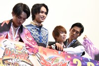 腰のマフラータオルが見えるように背伸びする兵頭功海（中央左）と、小原唯和（中央右）に抱きつく岸田タツヤ（右端）。