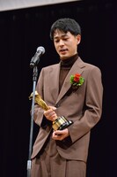 トロフィーの重みを噛みしめる成田凌。