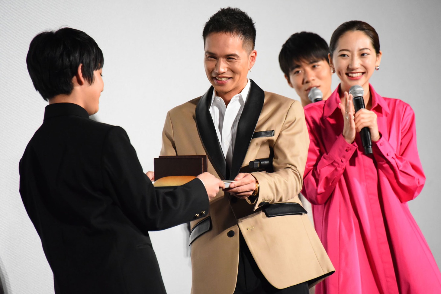 佐藤大志（左）がチョコレートコッペパンを市原隼人（中央）と武田玲奈（右）に渡す様子。