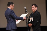 プレゼンターのコメントを恐縮しながら聞く武内英樹（右）。