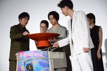 千葉雄大（中央）の持つ盃に酒を入れる登壇者たち。