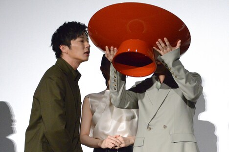 残りの酒の量を確認する田中圭(左)。