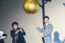 くす玉を割ろうとするポン・ジュノ（左）とソン・ガンホ（右）。