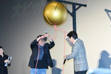 くす玉を割ろうとするポン・ジュノ（左）とソン・ガンホ（右）。