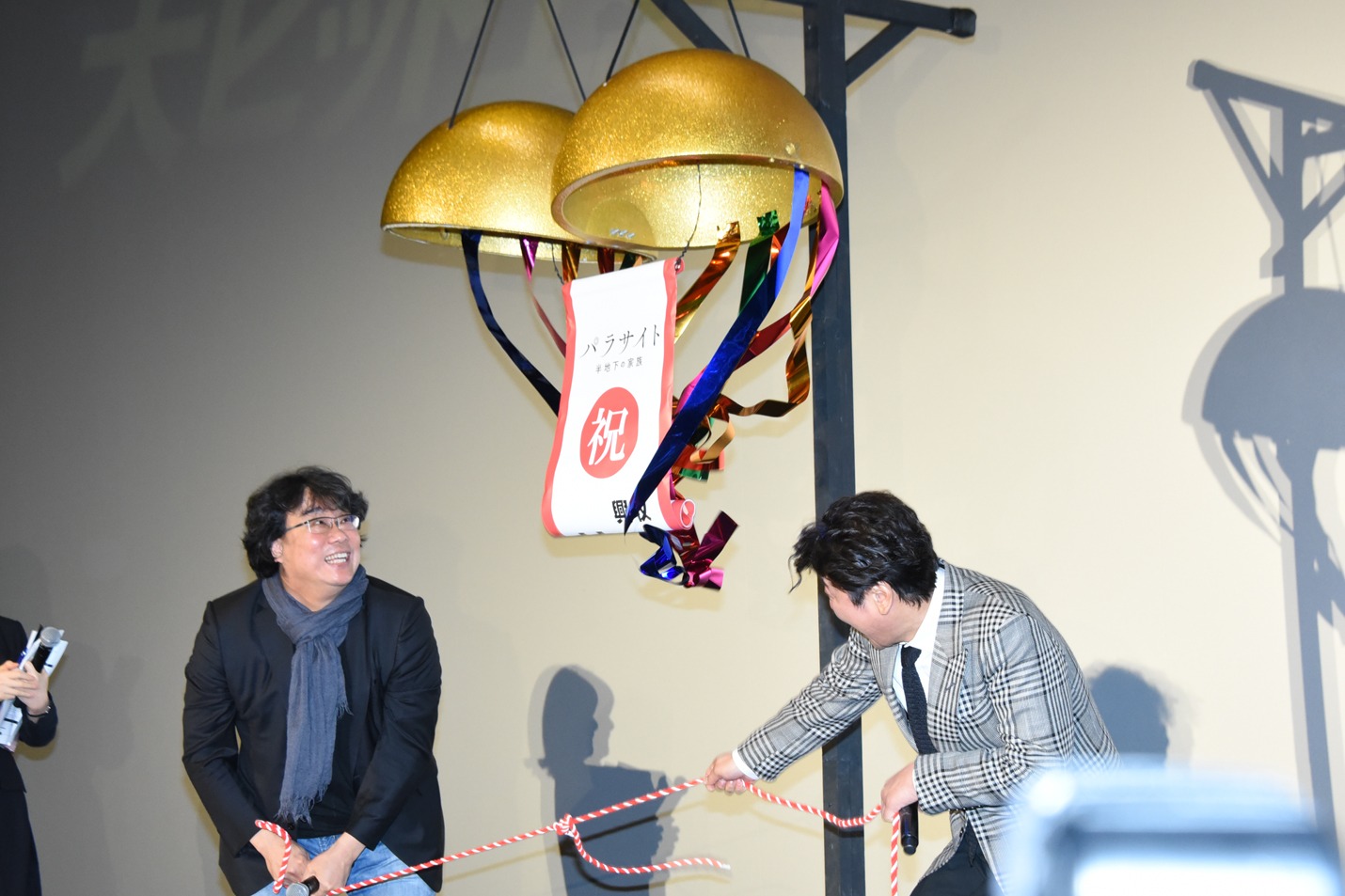 くす玉を割るポン・ジュノ（左）とソン・ガンホ（右）。