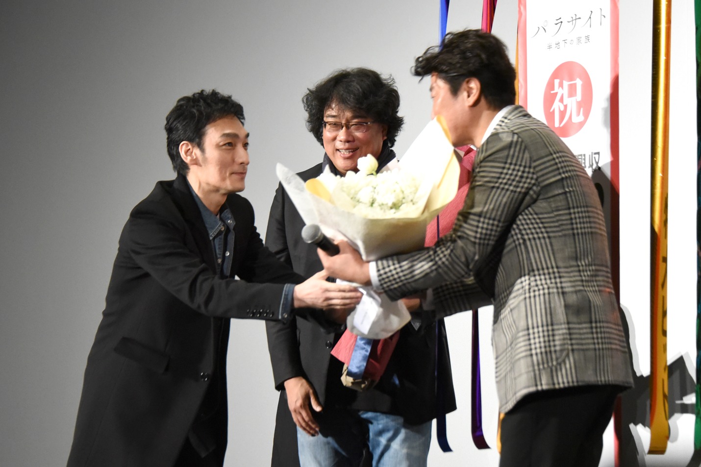 ソン・ガンホ（右）に花束を渡す草なぎ剛（左）。